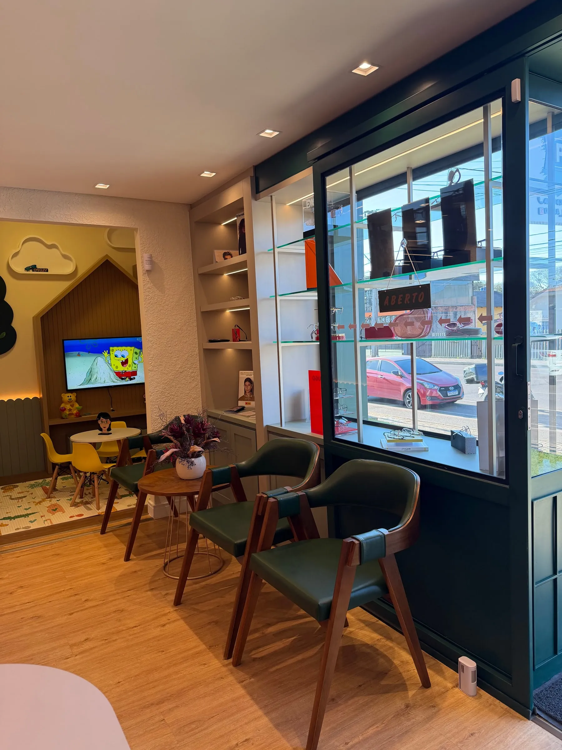 Cadeiras de espera junto à vitrine e o cantinho infantil