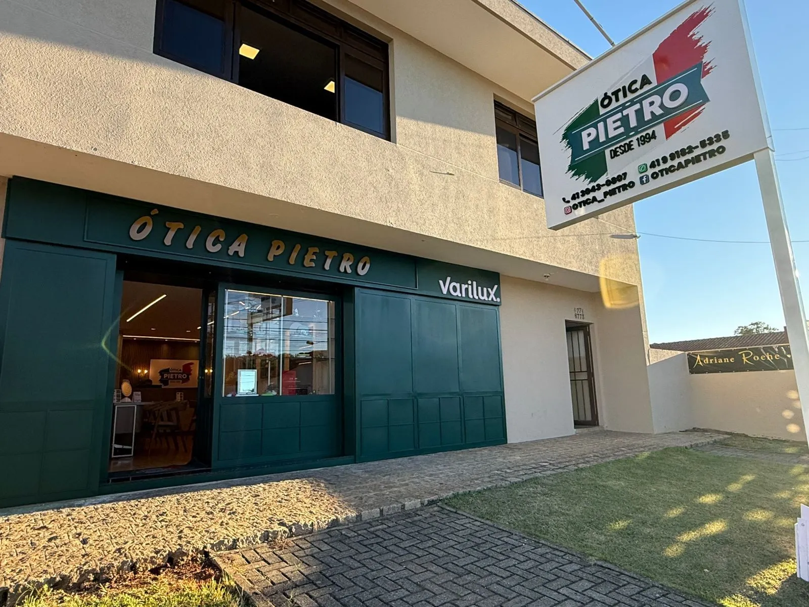 Fachada da Ótica Pietro no fim da tarde, com a porta de vidro aberta
